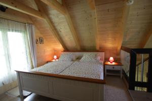 ein Schlafzimmer mit einem Bett in einem Holzhaus in der Unterkunft Ferienwohnungen Soravia in Gamlitz