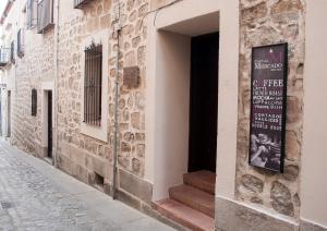un edificio con un letrero al lado de una calle en Palacio de Monjaraz en Ávila