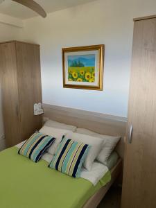 a bedroom with a bed with a painting on the wall at Apartments Vila Vino in Sveta Nedelja