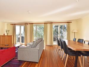 a living room with a table and a couch and chairs at Villa 3br Chambourcin Villa located within Cypress Lakes Resort in Pokolbin