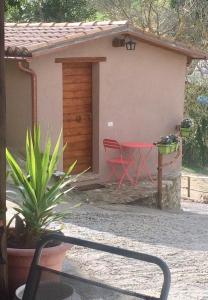 uma casa com uma mesa vermelha e cadeiras num quintal em la casetta delle more (monolocale) em Spoleto