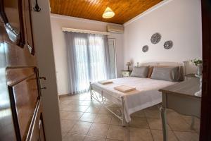 a bedroom with a bed and a table in a room at Liapades Cottage House in Gardeládes