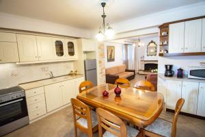 una cucina e una sala da pranzo con tavolo e sedie in legno di Liapades Cottage House a Gardeládes