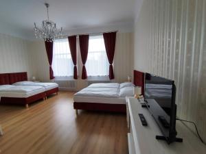 Una sala de estar con dos camas y un televisor. en Liahof, en Ullared 119 fotos más