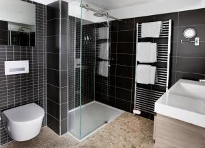 a bathroom with a shower and a toilet and a sink at Apart! Food & Drinks Apartments in Zwolle