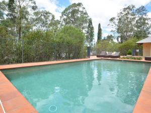 a swimming pool with blue water in a yard at Villa 3br Beaujolais located within Cypress Lakes Resort in Pokolbin