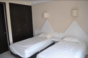 two beds sitting next to each other in a bedroom at Suite Club Deportivo in Acapulco +14 photos