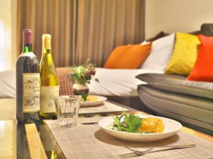 Chikusachō的住宿－ケイアイコンホテルズ ふくしあ503，一张桌子,上面放着两瓶葡萄酒和一盘食物