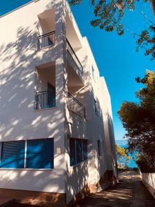 - un bâtiment blanc avec des balcons sur le côté dans l'établissement Hotel Elu Iris, à Split