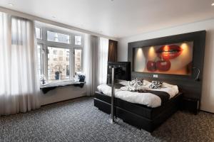 1 dormitorio con 1 cama y una pintura en la pared en Apart! Food & Drinks Apartments en Zwolle