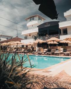 a swimming pool with chairs and umbrellas in a hotel at ESQUIRE HOTELS and LOUNGES in Kemer