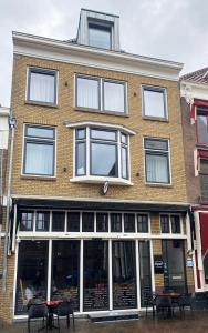 ein Backsteingebäude mit Tischen und Stühlen davor in der Unterkunft Apart! Food & Drinks Apartments in Zwolle