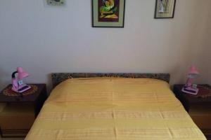 a bedroom with a bed with two lamps on tables at just on the beach 'Zamalin' in Tribunj