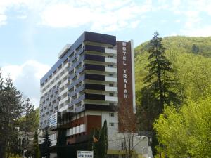 a building with a sign on the side of it at Hotel Traian Caciulata in Călimăneşti