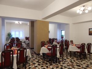 uma sala de jantar cheia de mesas e cadeiras em Hotel Traian Caciulata em Călimăneşti