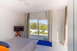 a bedroom with a bed and a large window at Villa Mary in Olbia