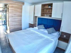 a bedroom with a large bed with a blue headboard at Bonita HouseBoat Apartment Portorose in Portorož