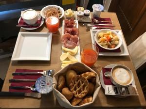 a table topped with plates of food and drinks at Luxury Venetian Rooms in Venice