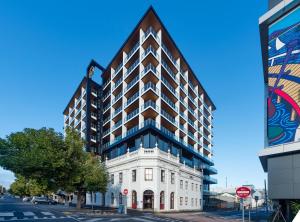 a large white building on a city street at Oaks R Suites Geelong in Geelong