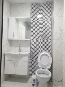 a white bathroom with a toilet and a sink at Konyaaltı Apart Hotel in Antalya