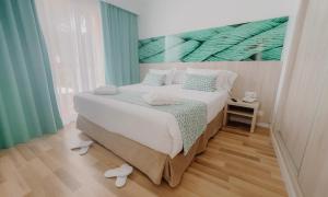 a bedroom with a bed with a painting on the wall at Comitas Floramar in Cala Galdana