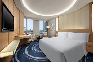 um quarto de hotel com uma cama grande e uma televisão em Shenzhen Futian Crowne Plaza Hotel,Near by Futian Station and Coco Park, Outdoor Heated Pool em Shenzhen