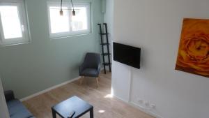 a living room with a television and a painting on the wall at Logements Le232 fr in Chasseneuil-du-Poitou