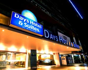 a building with a blue sign on the side of it at Days Hotel & Suites by Wyndham Fraser Business Park KL in Kuala Lumpur