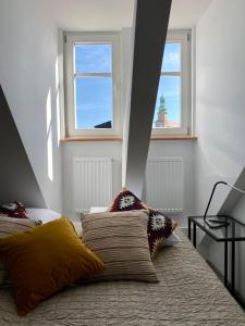 a bedroom with two pillows on a bed with two windows at apartament Hrabala in Jelenia Góra