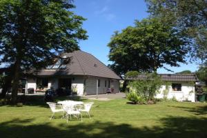 una mesa y sillas en el patio de una casa en F-1064 Rhododendronbluete in Lietzow, en Lietzow