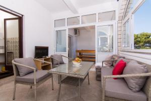 a living room with a table and chairs at Apartmani Mlačić in Okrug Donji