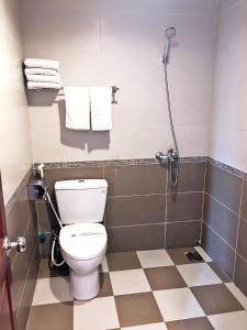 a bathroom with a toilet and a shower with towels at White Palace 2 in Thái Bình