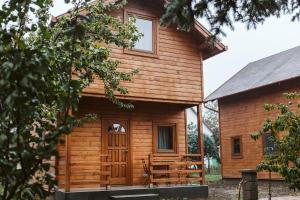 Cabaña de madera con porche y puerta en MINARDI vendégházak, en Berekfürdő