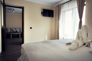 a bedroom with a bed with white sheets and a window at London Apartments Vaslui in Vaslui