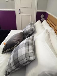 a bed with two pillows on top of it at Burleigh Guest House in Llandudno