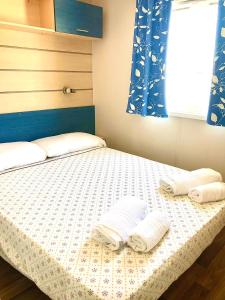 a bedroom with a bed with two towels on it at Camping Village Nice Garden in Ardea