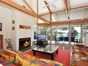 a living room with a couch and a fireplace at Lake Macquaries' Edgewater Escape at Morisset Memories in Morisset