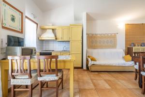 a kitchen with a table and chairs in a room at Masone Murgioni in Castiadas