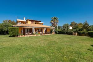 a house with a large lawn in front of it at Masone Murgioni in Castiadas