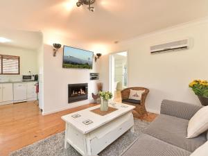 ein Wohnzimmer mit einem Sofa und einem Kamin in der Unterkunft Olive Grove 3 1 Bedroom Villa with large Bath in Pokolbin