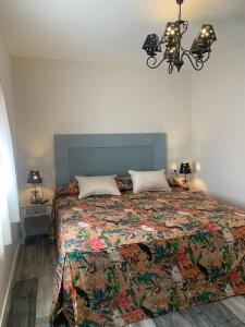 1 dormitorio con 1 cama con colcha colorida en Casa Rural Senda de los Lobos, en Uclés