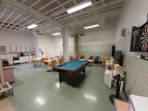 a room with a pool table and tables and chairs at Motel Ruskalinna in Pello