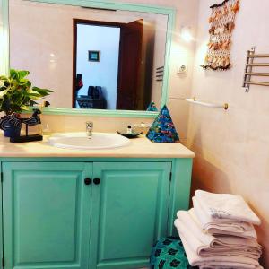 een badkamer met een wastafel en een spiegel bij CASA 19 in Albufeira
