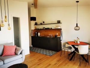 a living room with a table and a kitchen at Uferloft in Immenstaad am Bodensee