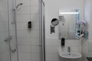 a bathroom with a shower and a sink at Apartment Hotel am Sand in Hamburg +31 photos