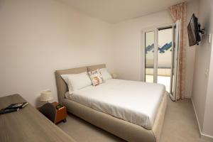 une chambre blanche avec un lit et une fenêtre dans l'établissement Kafara Resort- Villas and Pool by Lisca Bianca Rental, à Santa Flavia