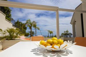 - un bol de fruits sur une table avec vue sur l'océan dans l'établissement Kafara Resort- Villas and Pool by Lisca Bianca Rental, à Santa Flavia