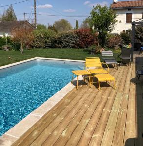 una terraza con 2 sillas y una piscina en Les Chambres Lauryvan, en Saint-Junien