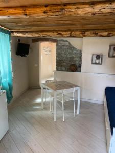 uma mesa e cadeiras num quarto com uma parede de pedra em A pochi passi dal mare em Monterosso al Mare