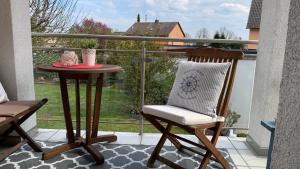 un balcone con tavolo e sedia sul portico di CROSSHILL Appartements - Charmante und helle Wohnung a Schwandorf